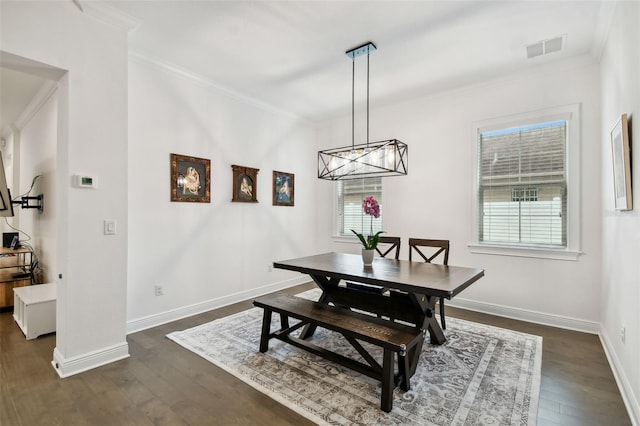 dining room with dark hardwood / wood-style floors, a notable chandelier, and ornamental molding