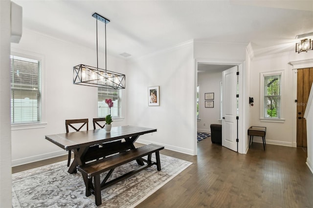 dining room featuring dark wood-type flooring, crown molding, and an inviting chandelier