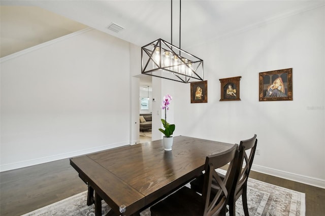 dining space with ornamental molding and dark hardwood / wood-style floors