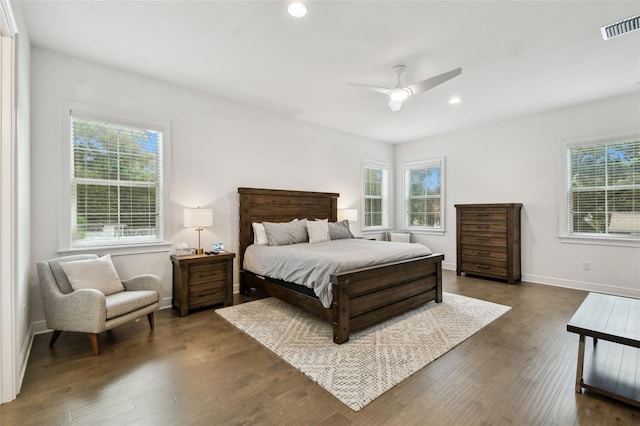 bedroom with multiple windows, dark wood-type flooring, and ceiling fan