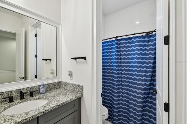 bathroom featuring curtained shower, vanity, and toilet