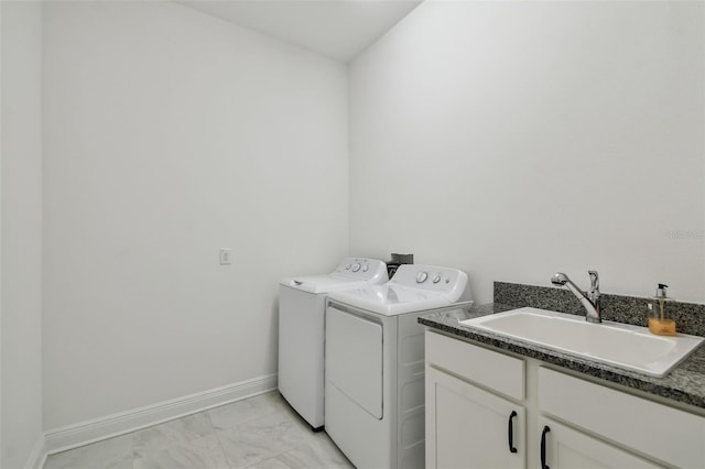 washroom featuring sink, washer and clothes dryer, and cabinets