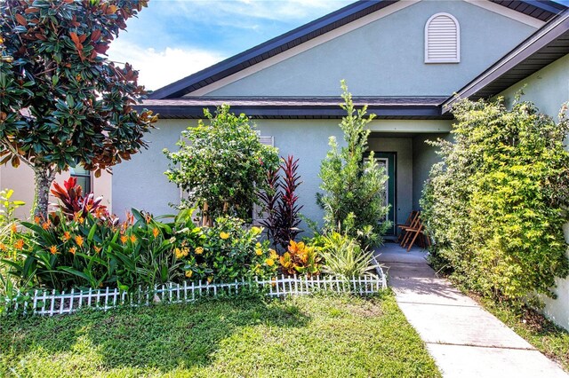 entrance to property featuring a lawn