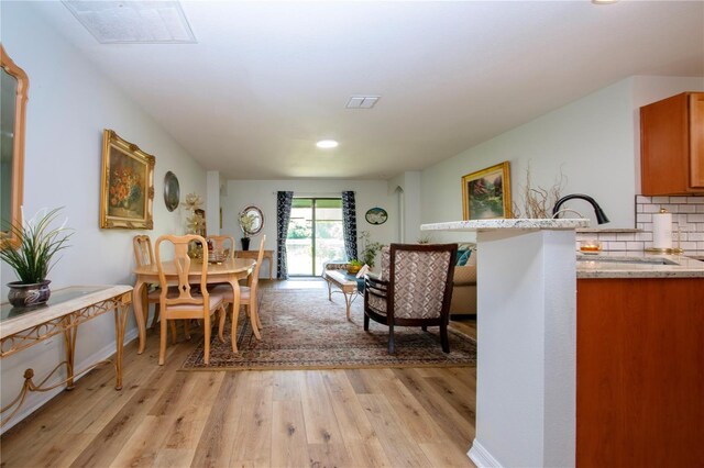 dining space featuring sink and light hardwood / wood-style flooring