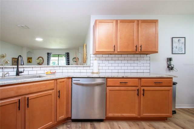 kitchen featuring backsplash, dishwasher, light hardwood / wood-style floors, sink, and light stone counters