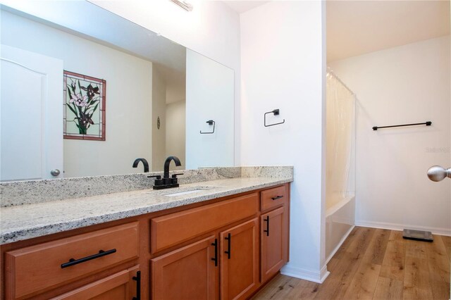 bathroom with vanity, wood-type flooring, and shower / bath combo