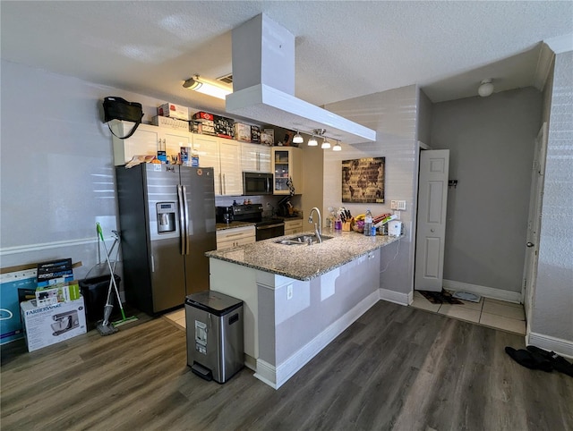 kitchen featuring black / electric stove, dark hardwood / wood-style floors, a textured ceiling, stainless steel fridge, and kitchen peninsula