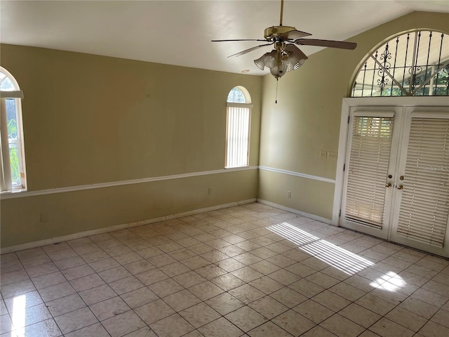 spare room featuring a wealth of natural light, light tile patterned floors, and ceiling fan