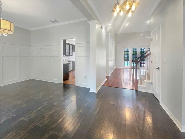 interior space with a notable chandelier, dark wood-type flooring, and crown molding