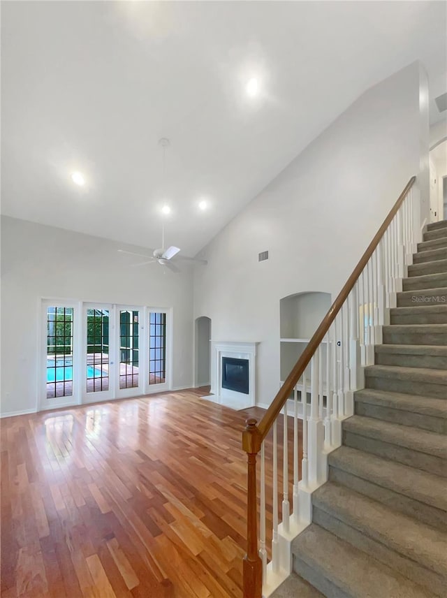 interior space with ceiling fan, high vaulted ceiling, french doors, and wood-type flooring