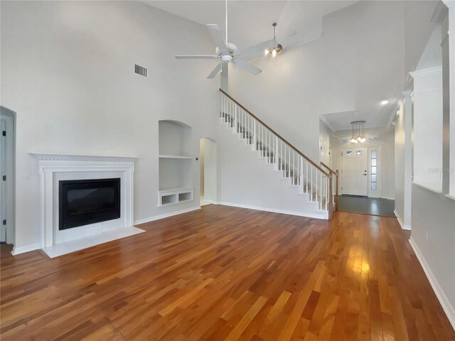 unfurnished living room with ceiling fan, high vaulted ceiling, hardwood / wood-style floors, and built in features