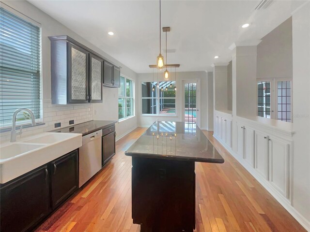 kitchen with decorative backsplash, light hardwood / wood-style flooring, decorative light fixtures, and stainless steel dishwasher