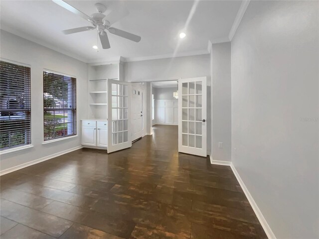 empty room with ceiling fan, dark hardwood / wood-style flooring, crown molding, and french doors