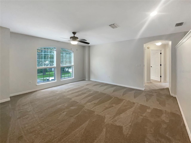 spare room with carpet floors, visible vents, and baseboards