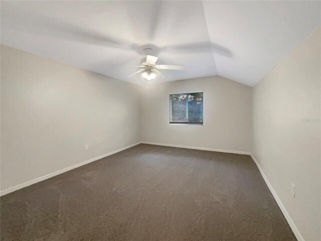 carpeted spare room featuring ceiling fan and vaulted ceiling