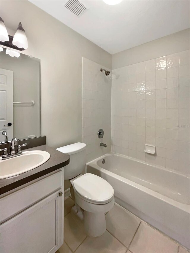 full bathroom featuring tiled shower / bath, toilet, tile patterned flooring, and vanity