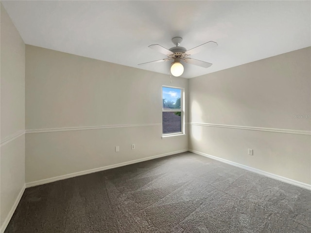 unfurnished room featuring ceiling fan, dark colored carpet, and baseboards