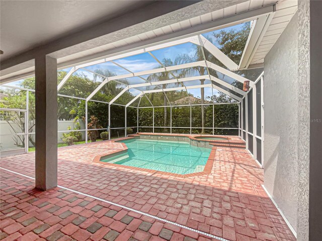 view of pool featuring glass enclosure and a patio