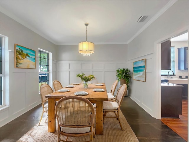dining space with a wainscoted wall, a decorative wall, visible vents, ornamental molding, and dark wood-type flooring