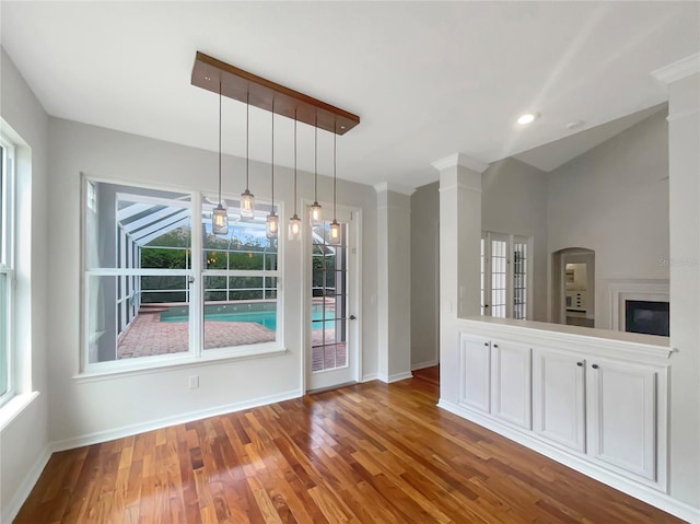 unfurnished dining area featuring plenty of natural light, baseboards, and wood finished floors