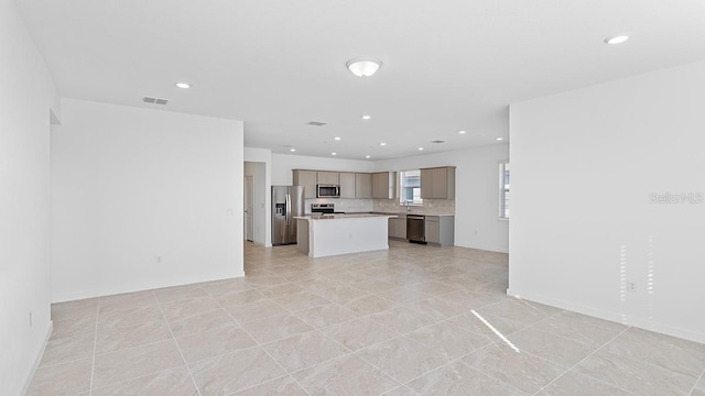 kitchen featuring stainless steel appliances, tasteful backsplash, a center island, and light tile patterned flooring