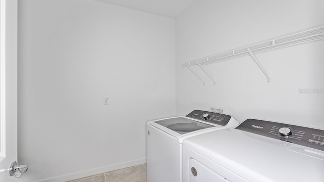 clothes washing area with separate washer and dryer and light tile patterned floors