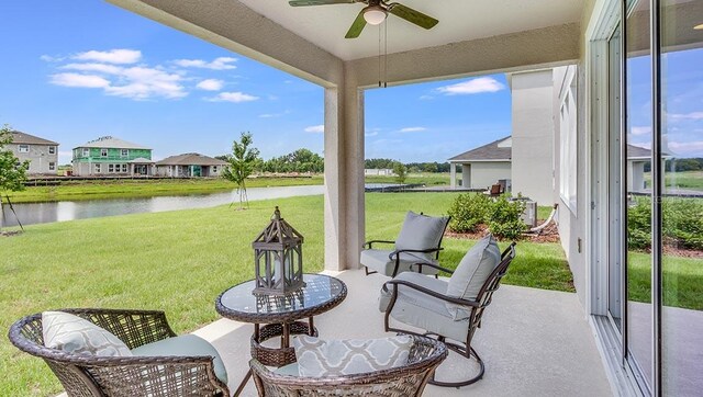 sunroom / solarium featuring ceiling fan and a water view