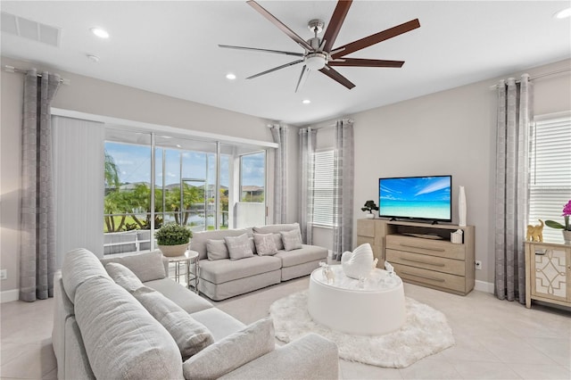 tiled living room with ceiling fan and a healthy amount of sunlight