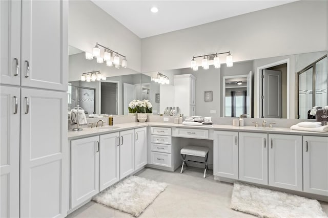 bathroom featuring tile patterned flooring, vanity, and a shower with shower door