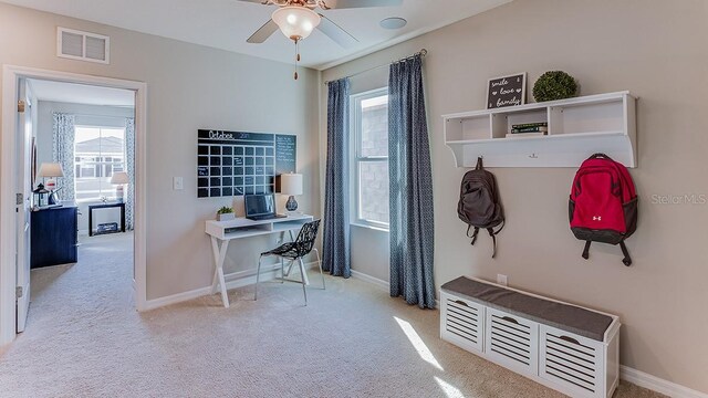 mudroom featuring ceiling fan, light colored carpet, and a healthy amount of sunlight