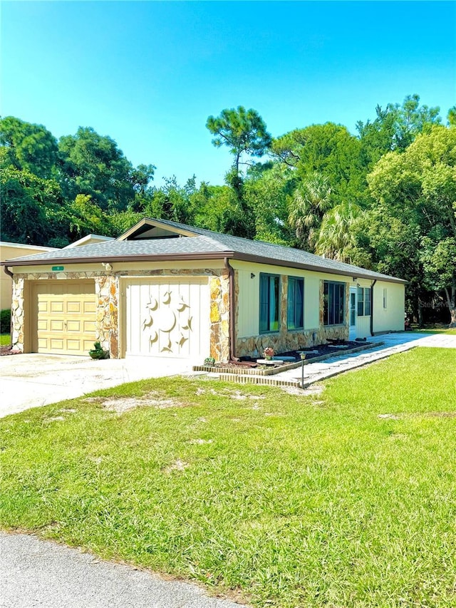 view of front facade featuring a garage, stone siding, concrete driveway, and a front yard