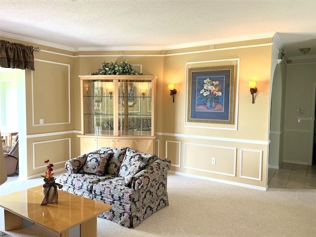 living room featuring a textured ceiling, ornamental molding, and light carpet