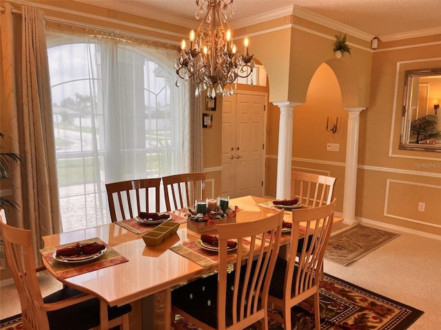 dining area with decorative columns, crown molding, and a chandelier