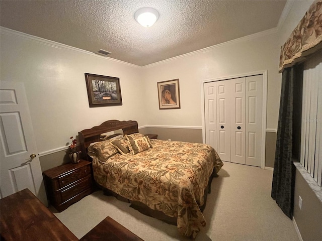 carpeted bedroom with a textured ceiling, a closet, and crown molding