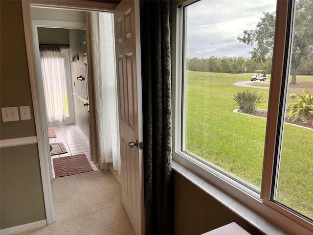 hall featuring a wealth of natural light and light colored carpet