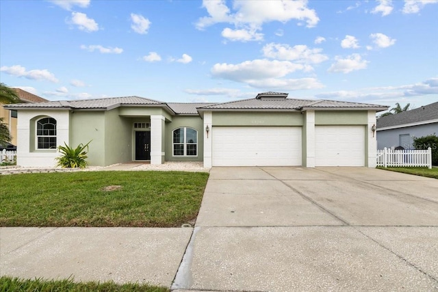 view of front of home featuring driveway, an attached garage, fence, a front lawn, and stucco siding