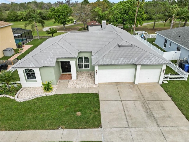 ranch-style house featuring a fenced backyard, a tiled roof, an attached garage, a front lawn, and stucco siding