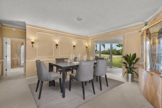 dining room with crown molding, visible vents, and carpet