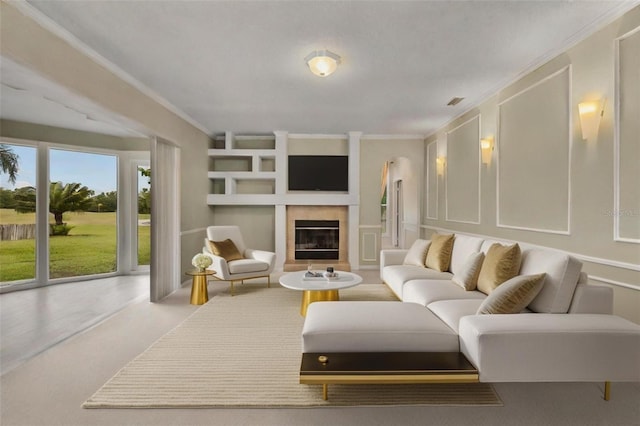 living room with crown molding, a decorative wall, carpet, a glass covered fireplace, and built in shelves