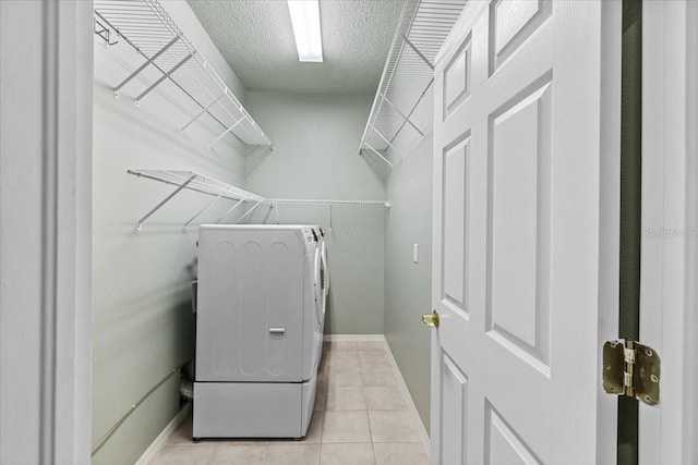 13102 Prestwick Dr, Riverview, FL 33579 - washroom featuring washing machine and clothes dryer, a textured ceiling, light tile patterned floors, and baseboards