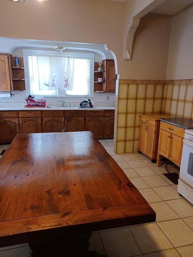 kitchen with brown cabinets, butcher block countertops, and open shelves