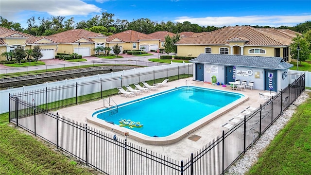 community pool featuring a patio area, a residential view, and fence