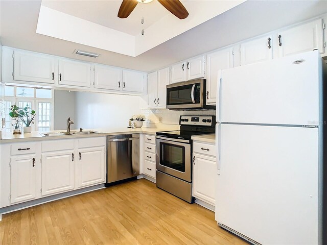 kitchen featuring ceiling fan, light hardwood / wood-style floors, stainless steel appliances, and white cabinetry