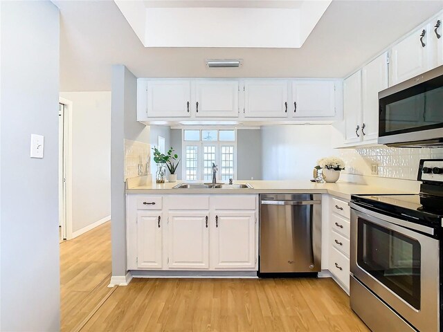 kitchen featuring sink, light hardwood / wood-style flooring, white cabinetry, and stainless steel appliances