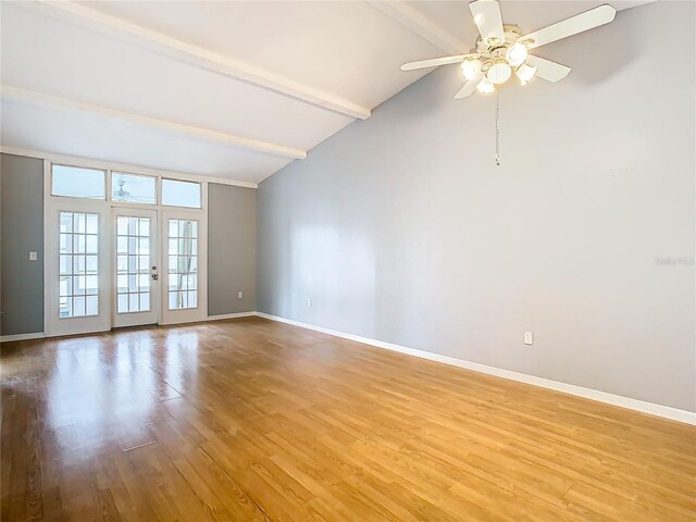 empty room featuring light wood-type flooring, lofted ceiling with beams, french doors, and ceiling fan