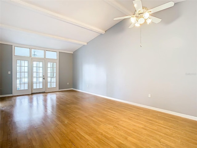 spare room featuring baseboards, beam ceiling, light wood-style flooring, and french doors