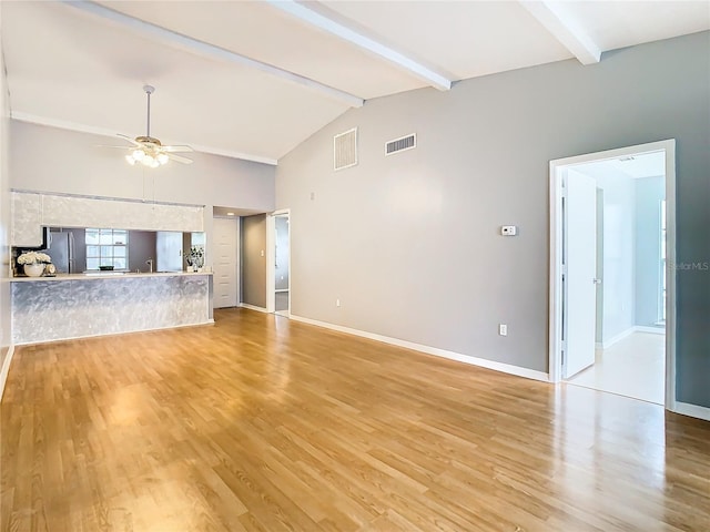 unfurnished living room with ceiling fan, high vaulted ceiling, beamed ceiling, and light hardwood / wood-style floors