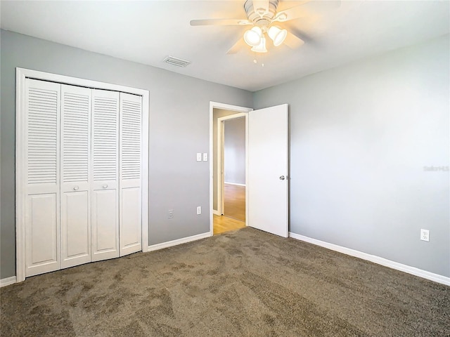 unfurnished bedroom with visible vents, a closet, carpet flooring, baseboards, and ceiling fan