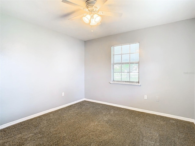 carpeted spare room with ceiling fan and baseboards