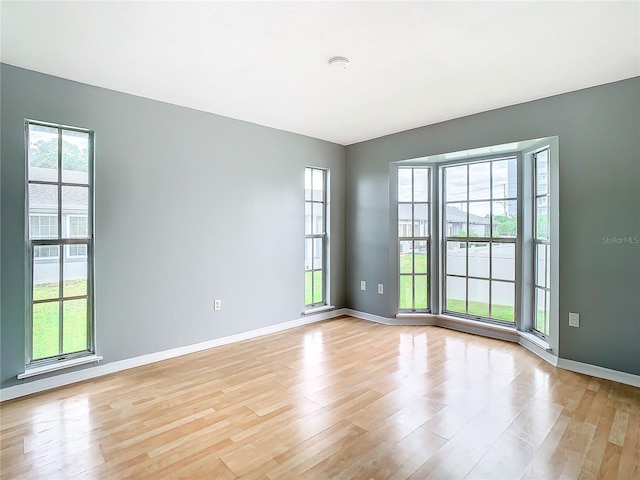 spare room featuring baseboards and light wood-style flooring